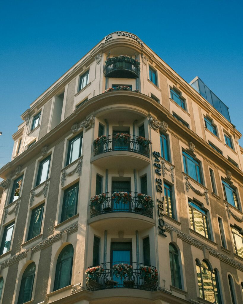 Außenansicht einer Gebäudeecke eines Hotels mit Balkonen.